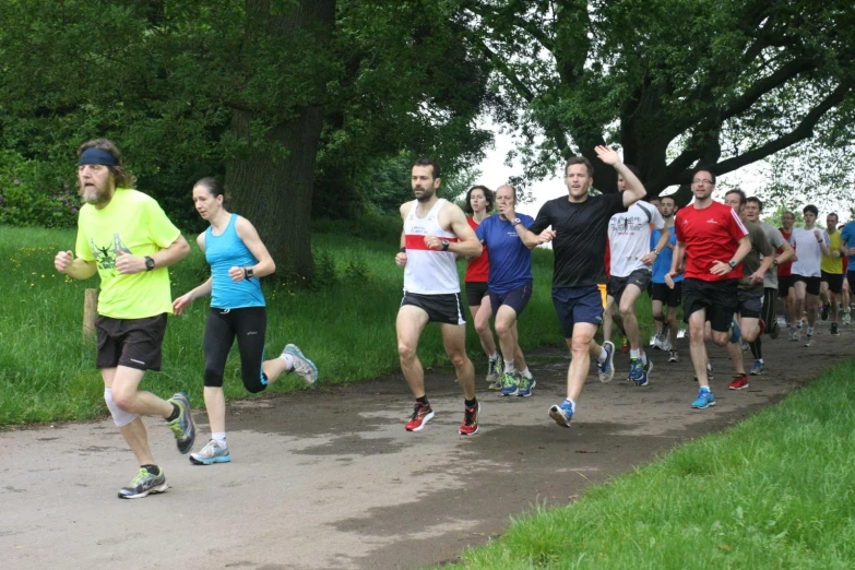 a number of people running on a path with trees in the background