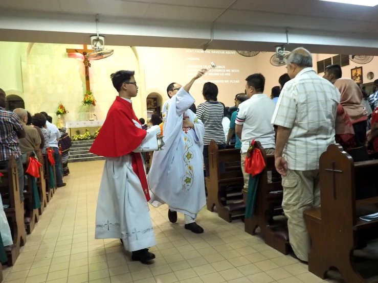 a man and a woman walking up the aisle at a religious ceremony