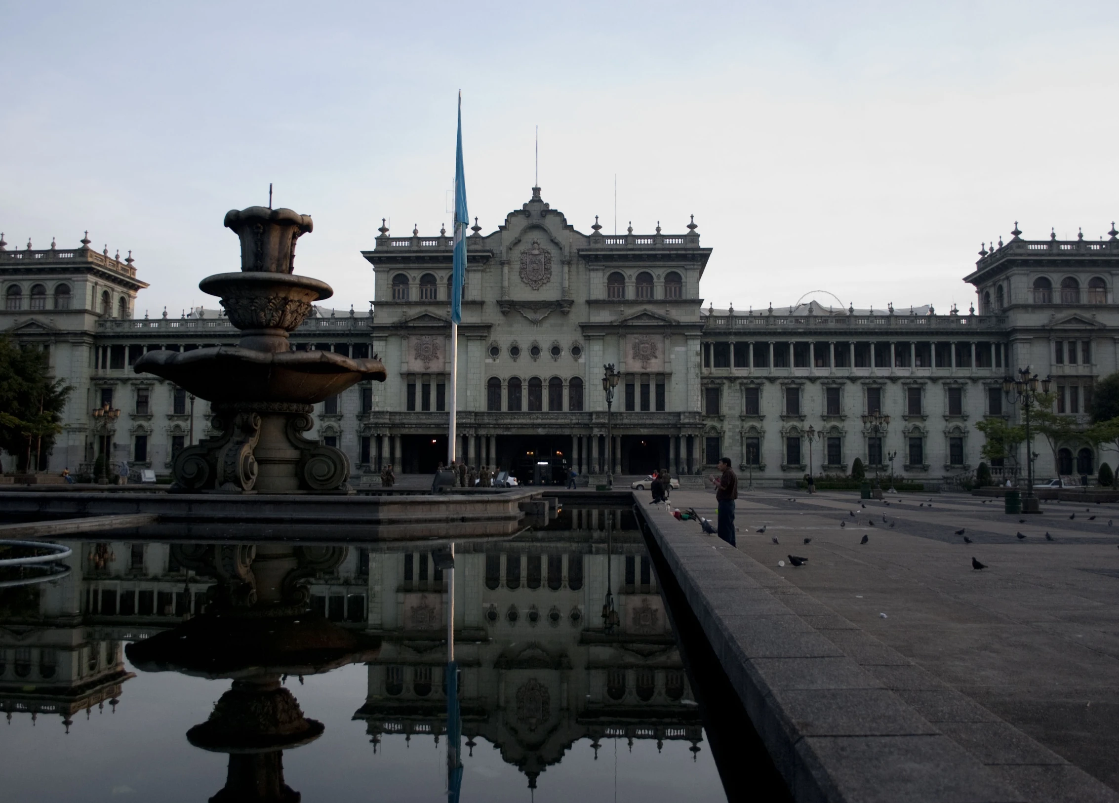 a fountain and a building near a pond