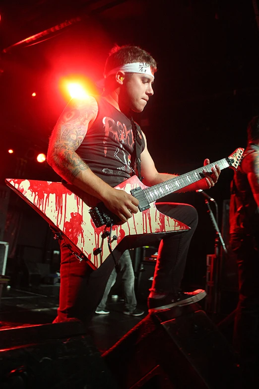 man with guitar and band playing in concert