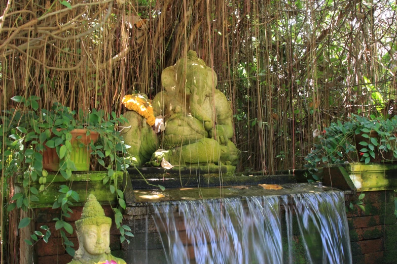 an outdoor waterfall in a garden with rocks and trees