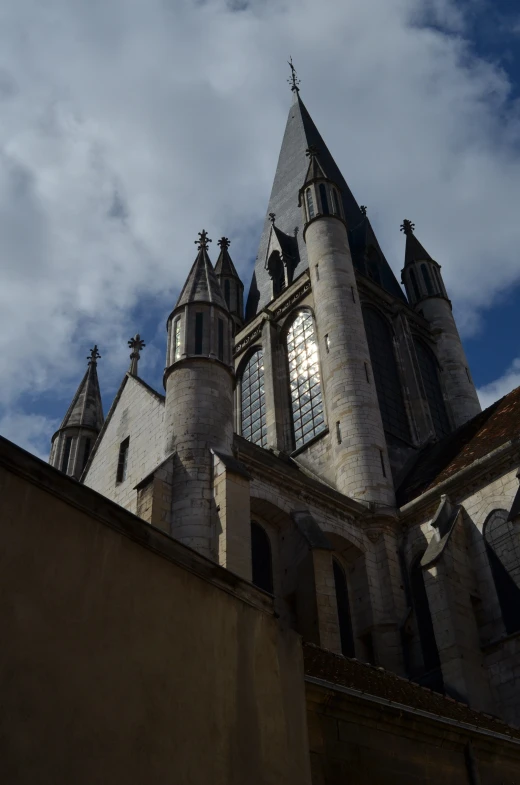 an old building with two towers against a cloudy sky