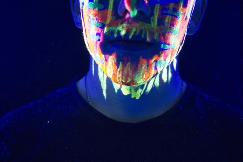 a man's face painted with neon colors