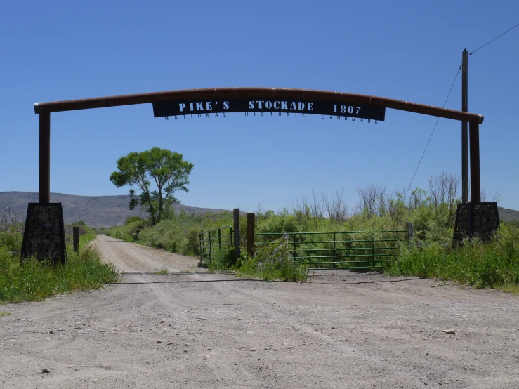 a road near a gate with an advertit for pike's soup bar