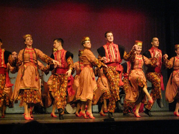 a group of women performing on stage with a man