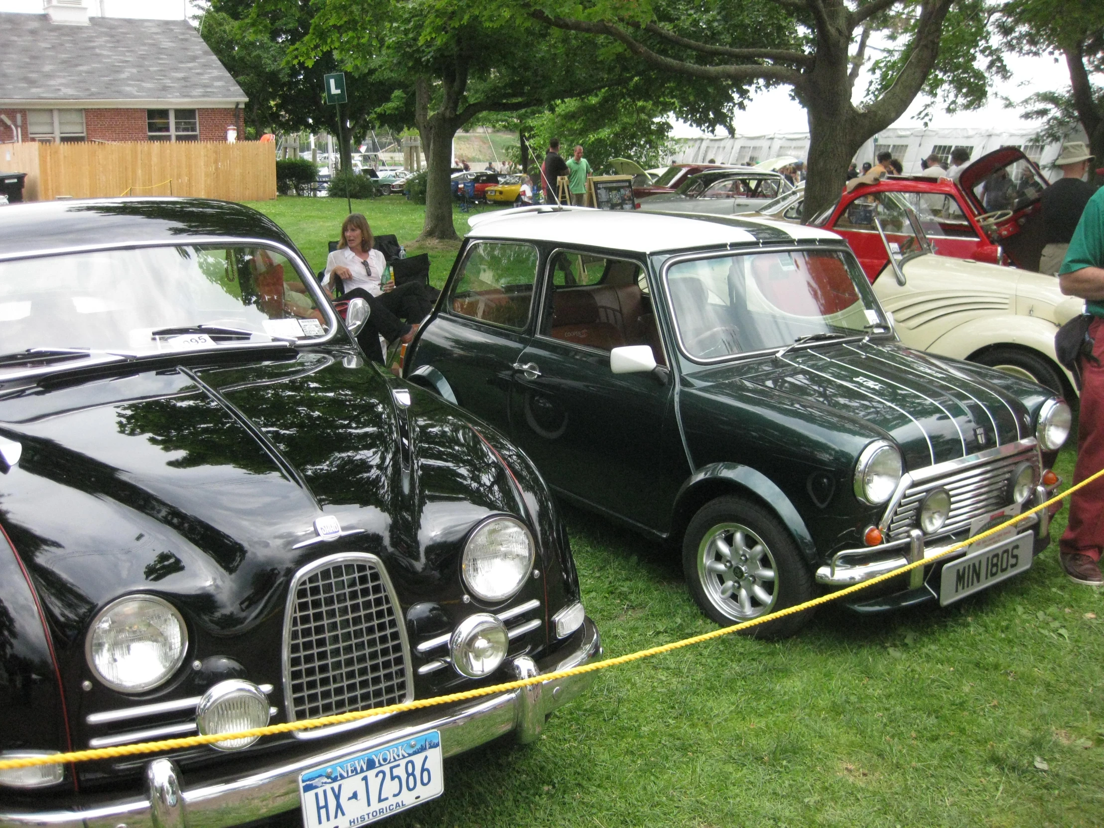 people are looking at two cars on display