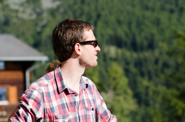 a person wearing a checkered shirt and sunglasses