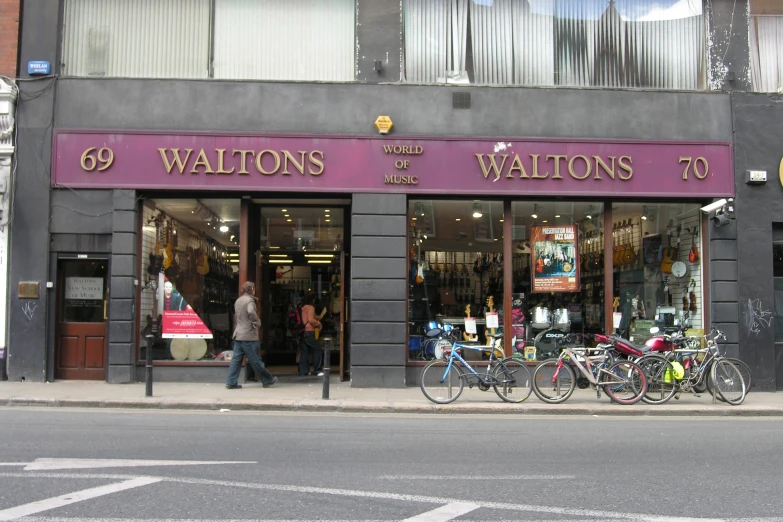 three bicycles outside of a store with a purple awning