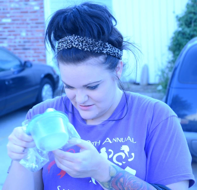 a girl with some hair in a bun and a purple shirt looking at soing