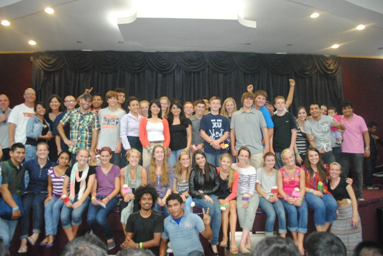 a group of young people are sitting in front of the stage