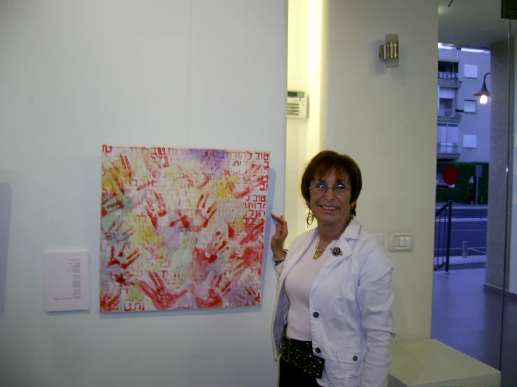 a woman is standing in front of a wall painting