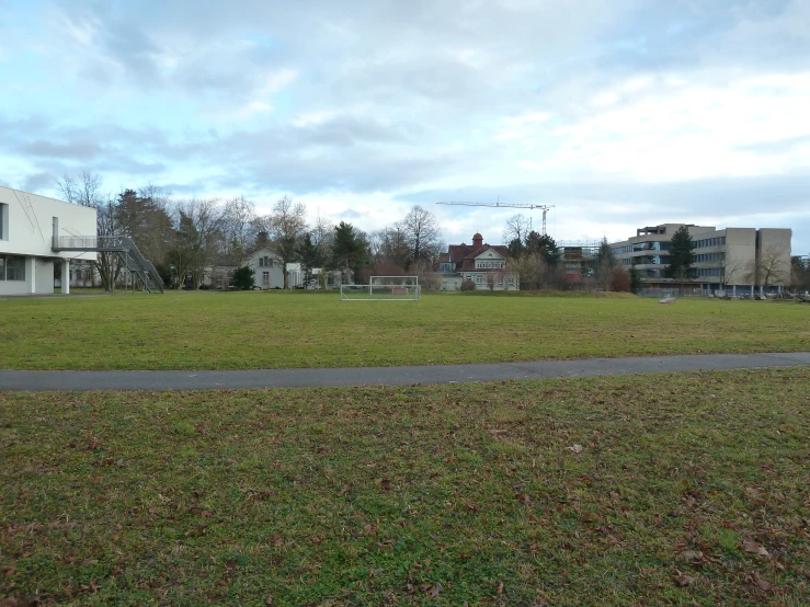 some grass buildings and trees in the distance