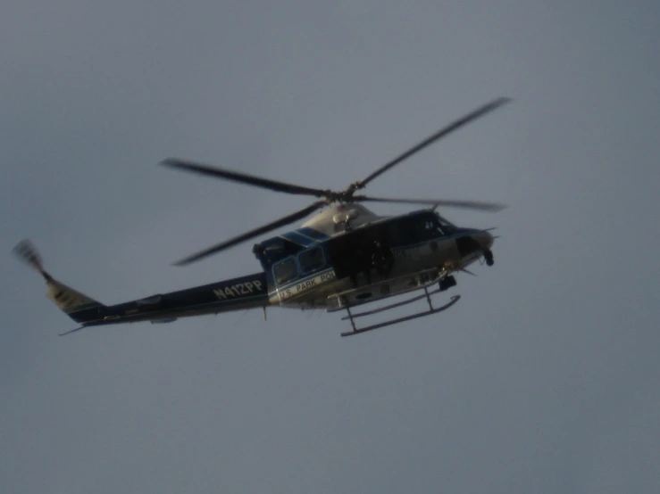 an helicopter is flying in the air with its wheels pointed