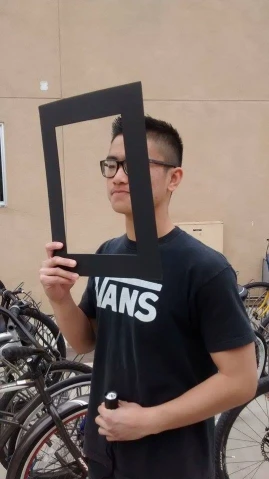 a boy is holding up a picture frame