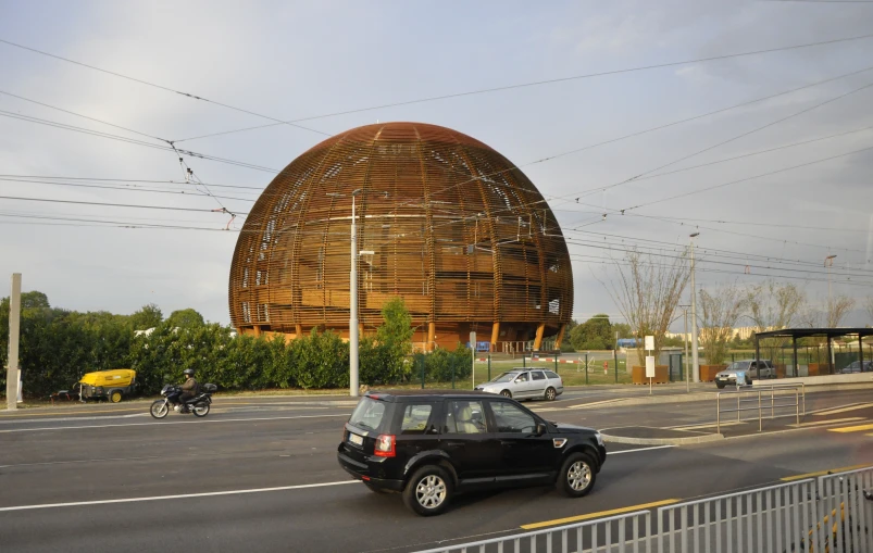 a black suv driving past a large dome like building