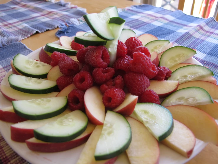 plate of assorted cut up vegetables and fruit for display