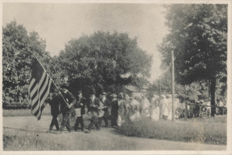 an old po of people standing around a flag