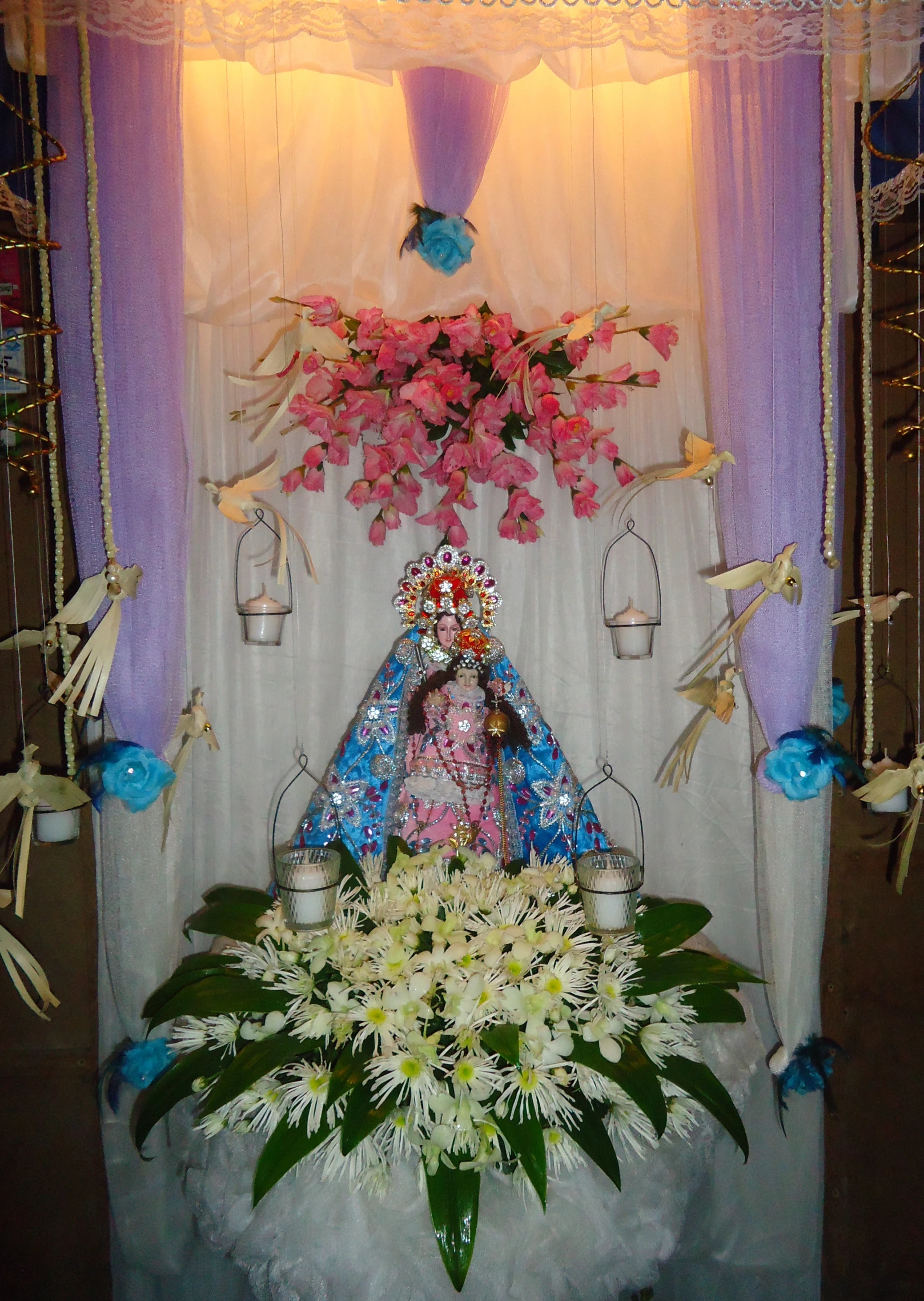 a shrine decorated in flowers and decorations on a table