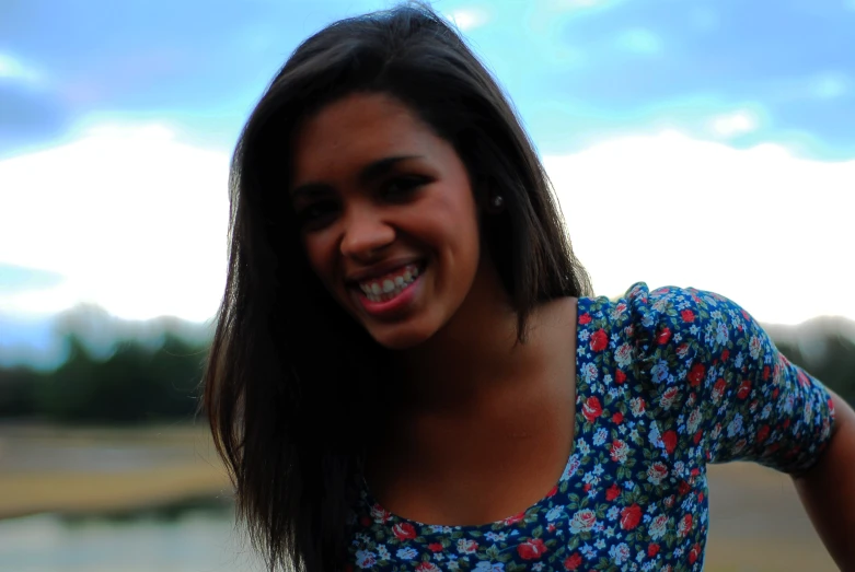 a woman smiles and puts her hand to her ear