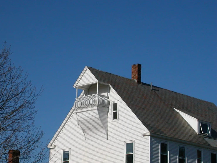 a white house with a roof and window shutters