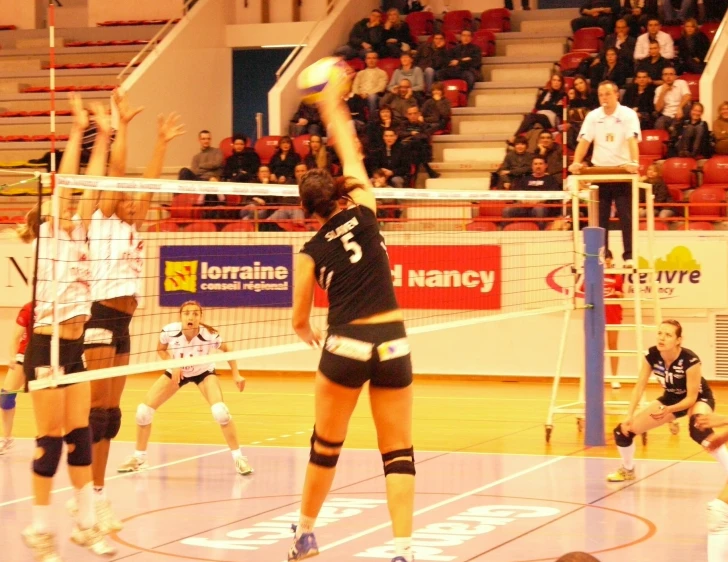 two girls are trying to hit the ball over the net