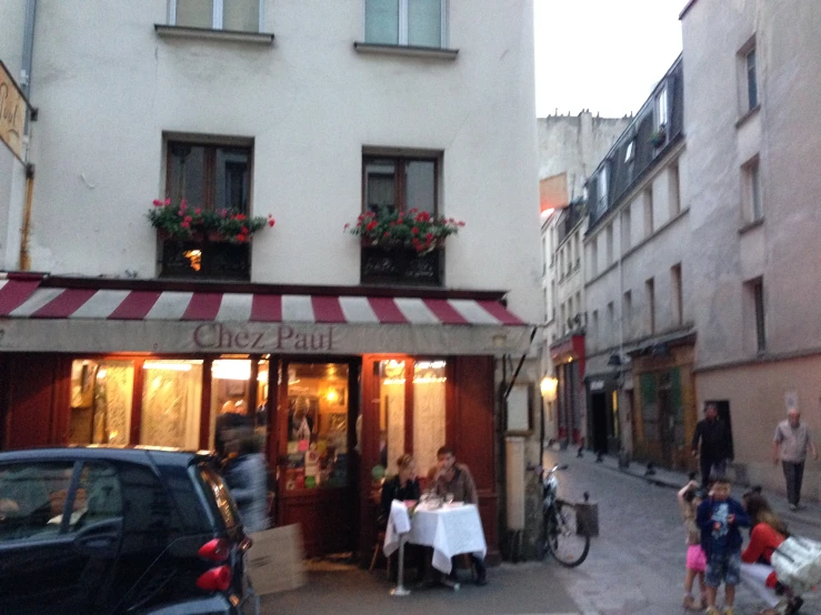 an outside of a restaurant with people and a few bikes