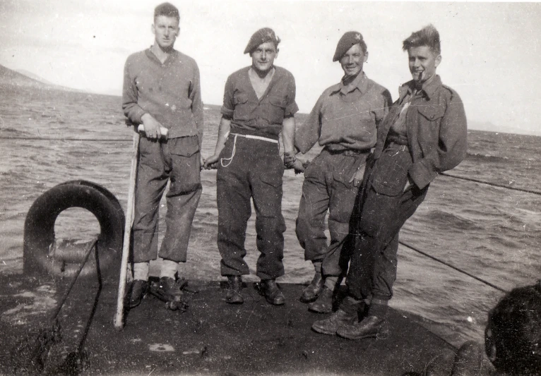 three men standing on a boat holding a fish