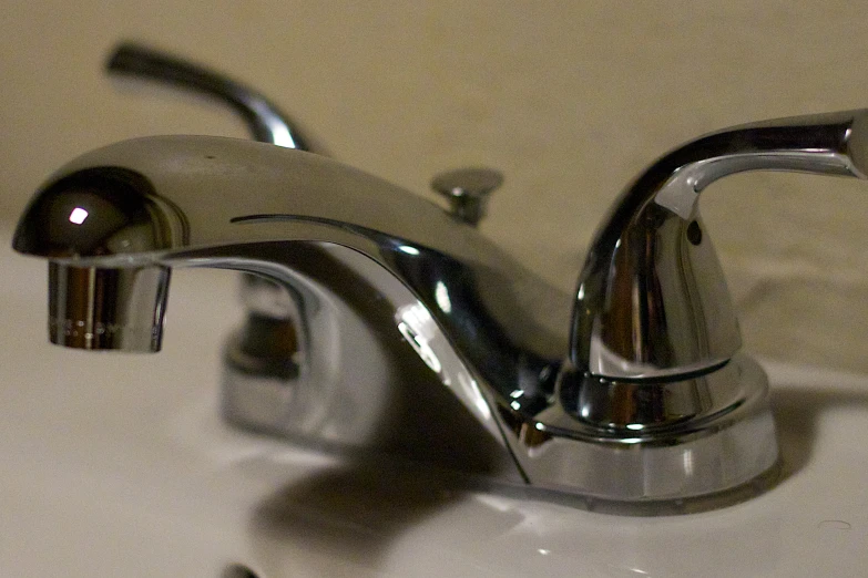 the faucet is dripping out of the shiny chrome faucet