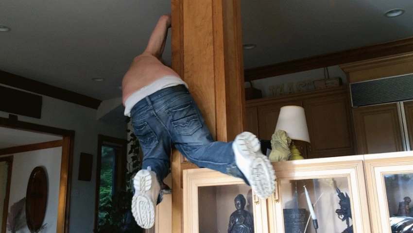 a man hanging from the ceiling while wearing his underwear