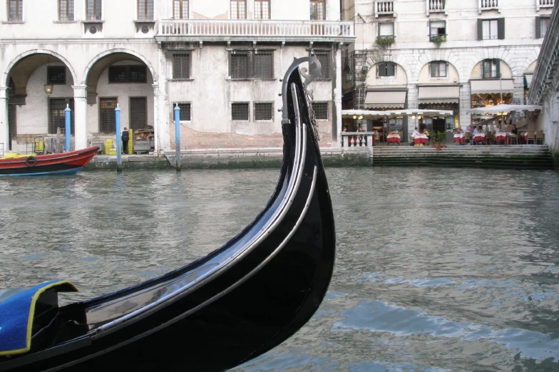 an open gondola boat moving through a canal