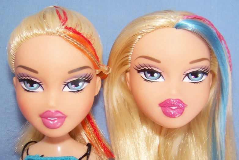two dolls are posed with long, blonde hair