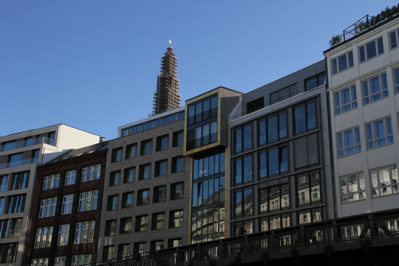 some buildings with glass windows and a clock tower in the background