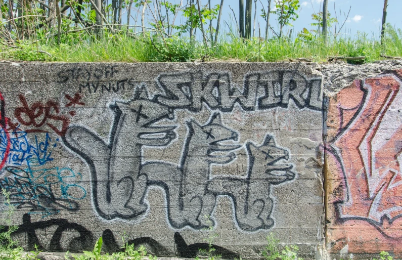 graffiti on a wall with one large stone that has been vandalized