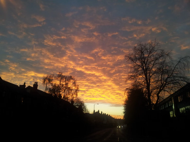 a sun setting on the horizon in front of houses