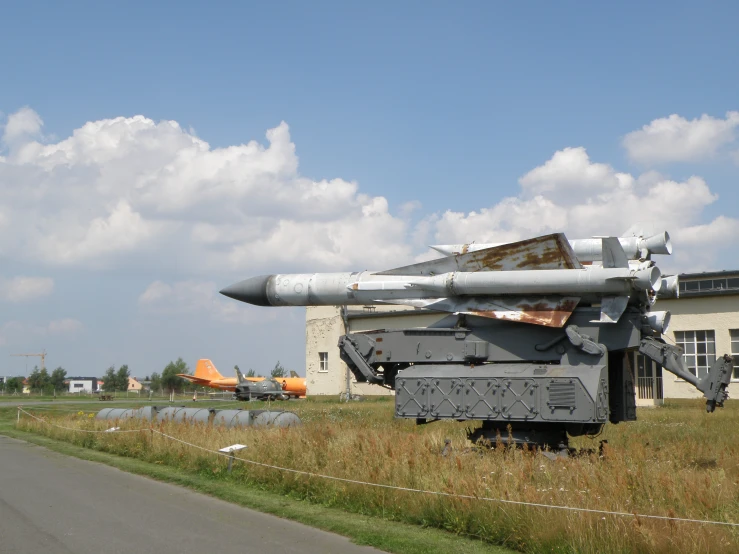 a military truck sitting in the grass next to a building