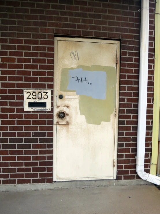 a door on the side of a brick building with graffiti on it