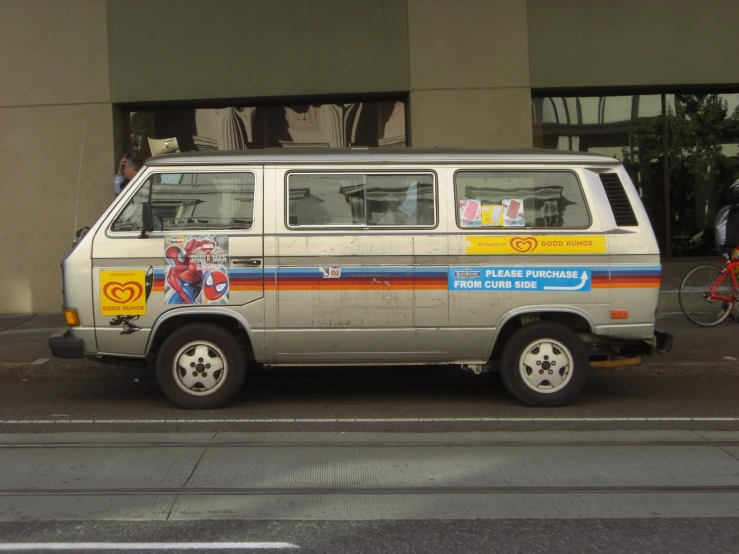 an old van with advertits sitting parked on the side of a street