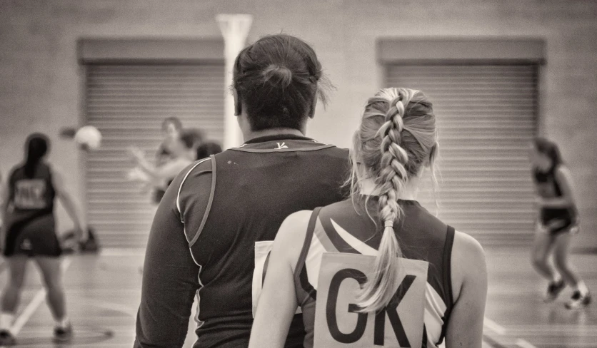 two girls with ponytails walking in the gym