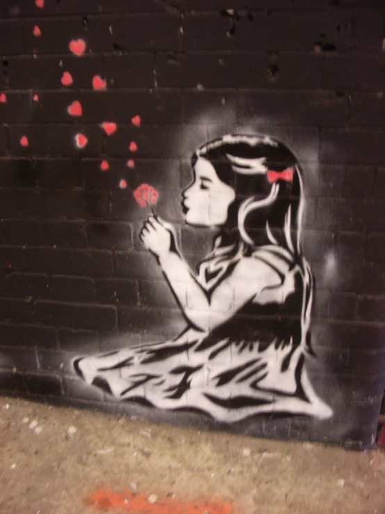 a graffiti on the side of a building of a girl blowing rose