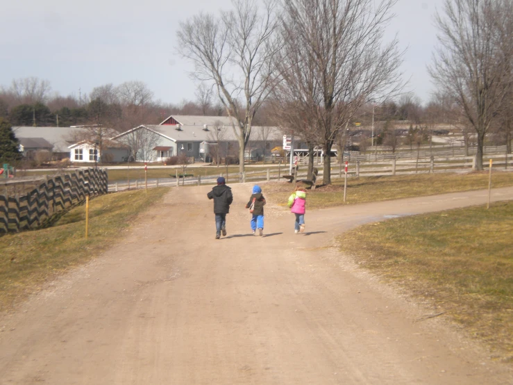 a father and two daughters walking down the road