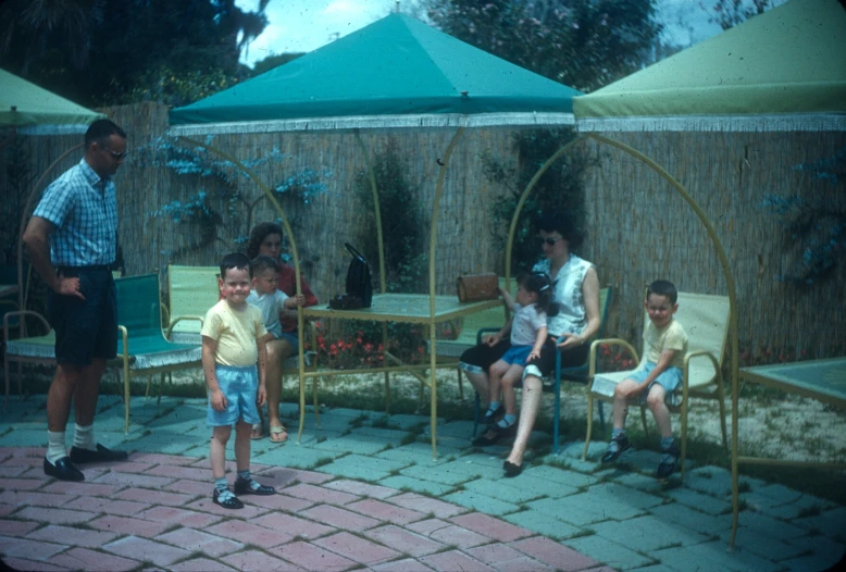 people sitting around in outdoor seating area next to plants