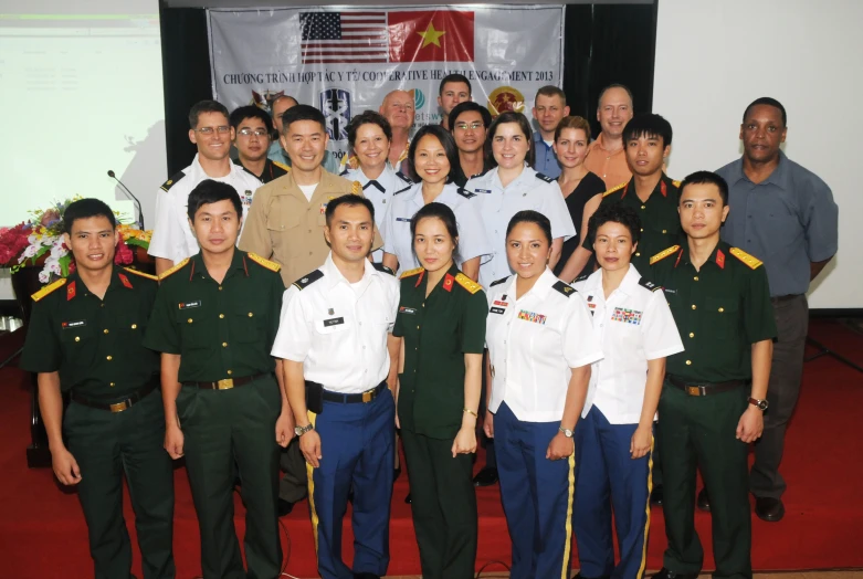 the group of military personnel are standing in front of a projection screen