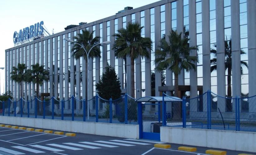 the blue fence and palm trees are lining the street