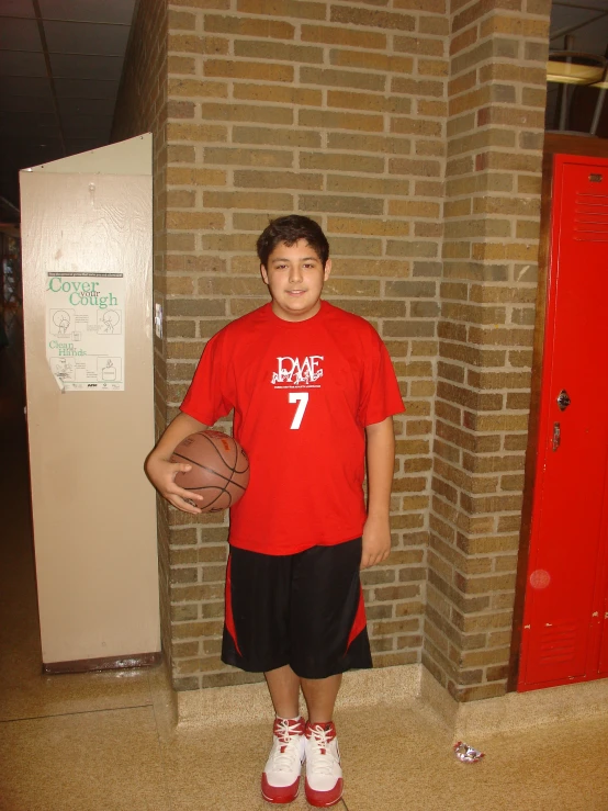 a  standing in front of a wall with a basketball