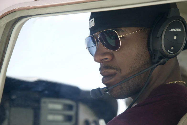 a man wearing sunglasses and headphones in a vehicle