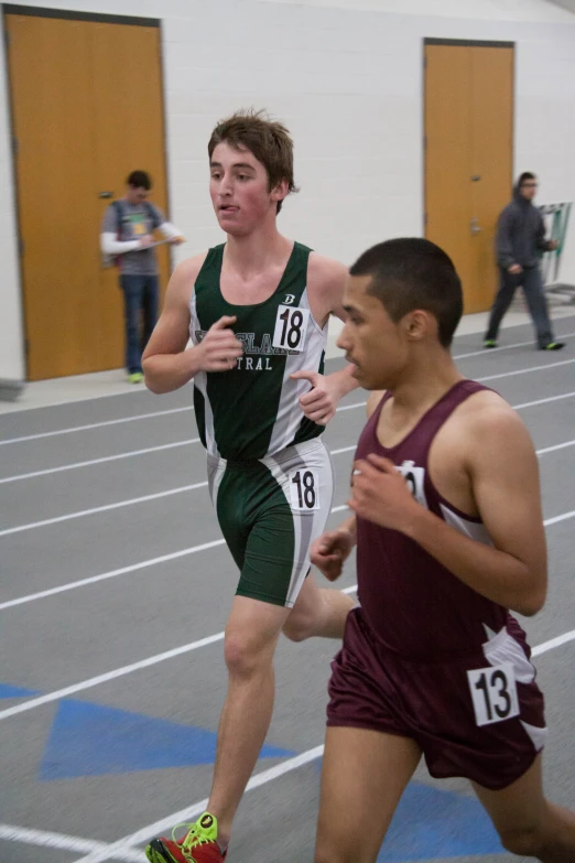 two people running on a track in a gymnasium