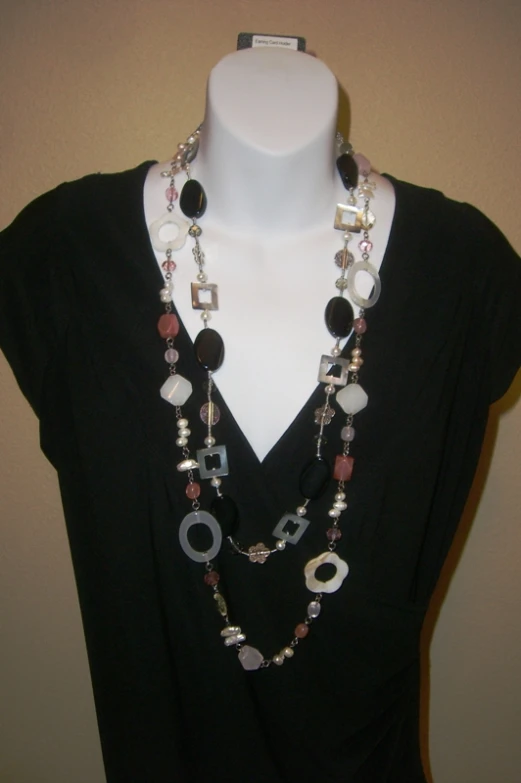 a necklace with beads and glass discs hanging from a dummy