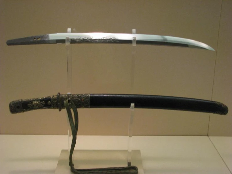 two metal swords standing on display in glass