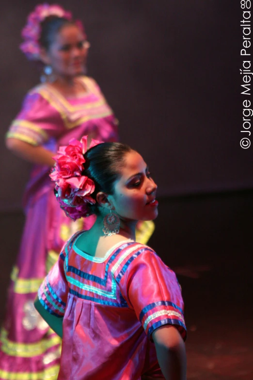 two ladies are dressed in colorful clothing and performing