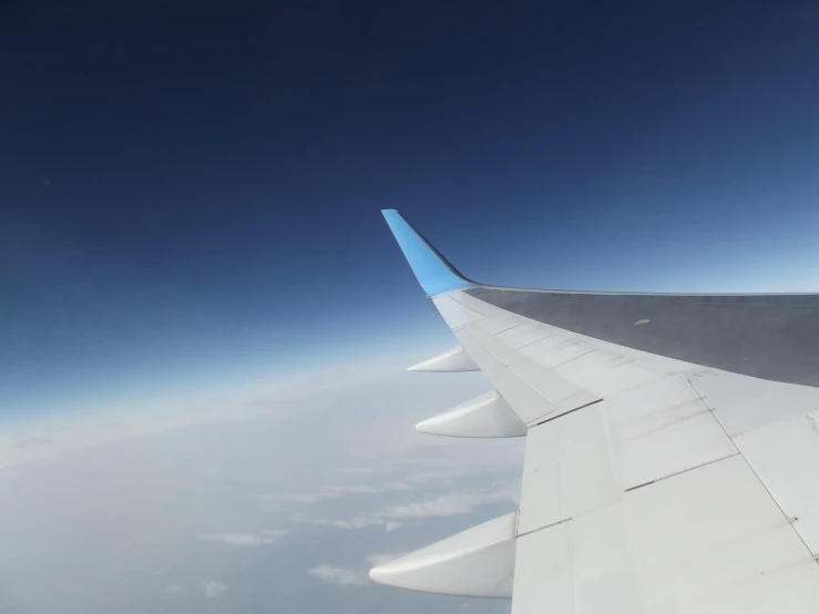 the wing of a plane flying in the sky